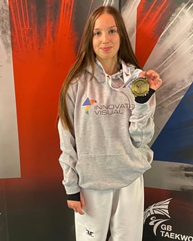 Phoenix wearing an IV branded hoodie and holding a gold medal