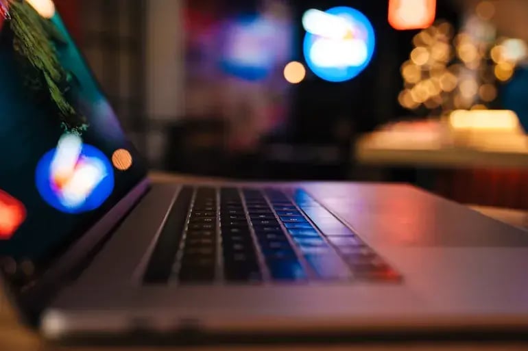 A Laptip on a table in a dark background
