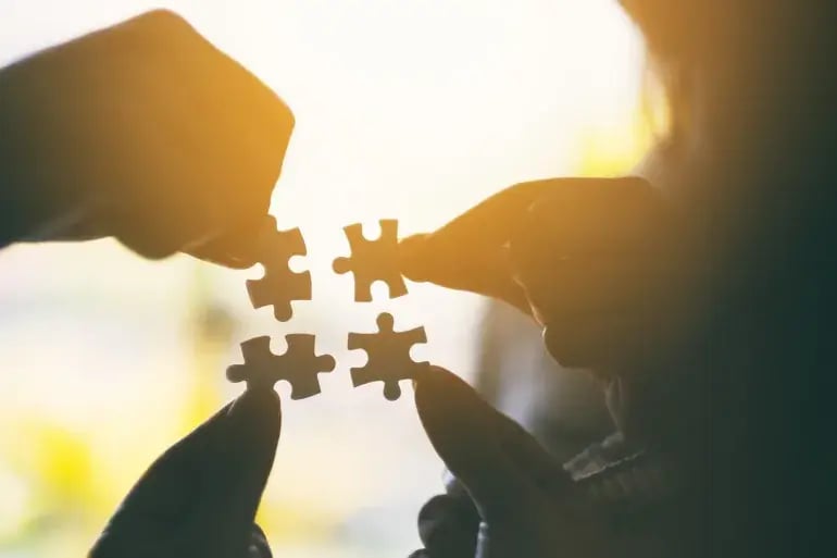innovation-visual-revops-transformations-concept-silhouette-of-hands-holding-4-jigsaw-pieces