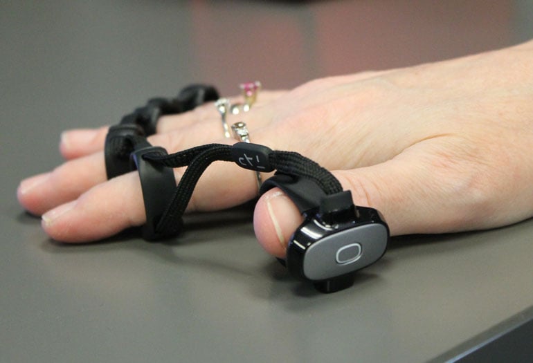 A woman using a haptic feedback device on her fingers.