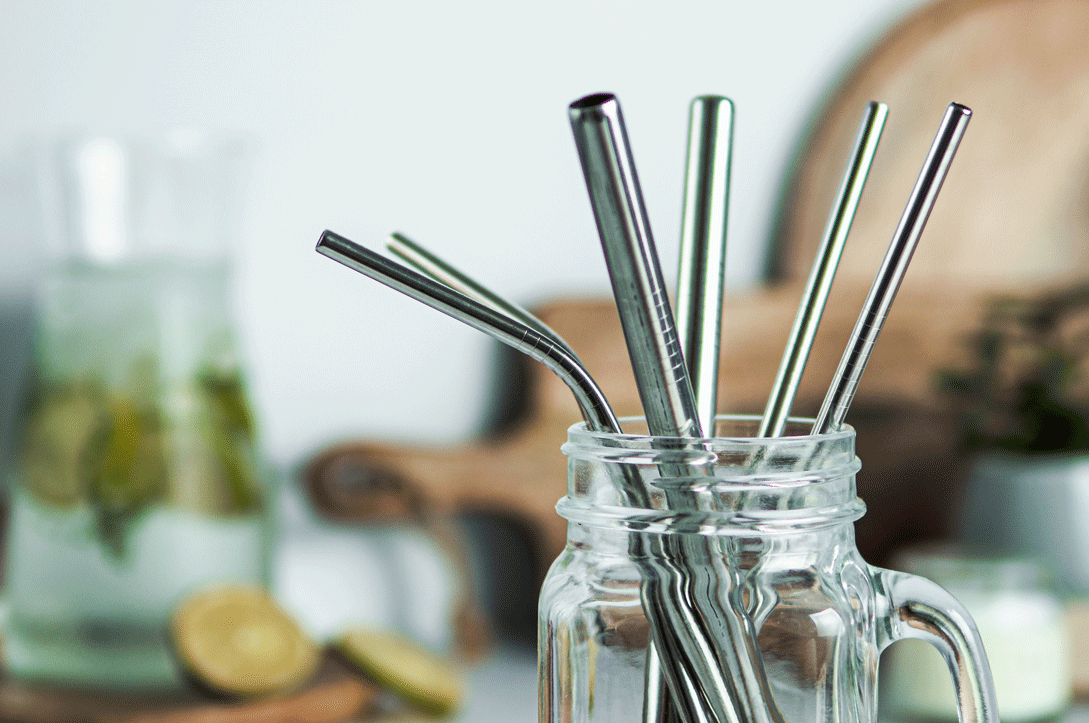Reusable metal straws in a glass mug.