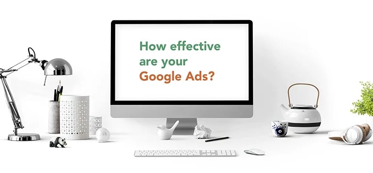 How effective are your Google Ads text written on desktop screen surrounded by desk objects 