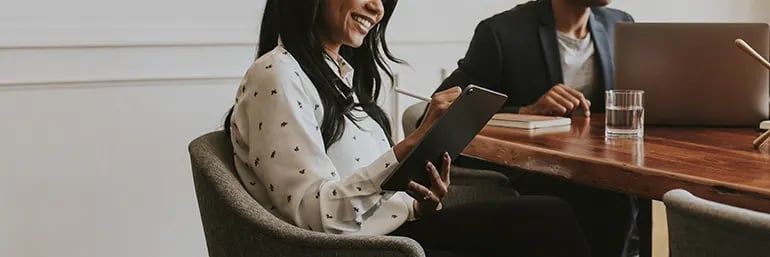 smiling business woman in RevOps meeting with tablet