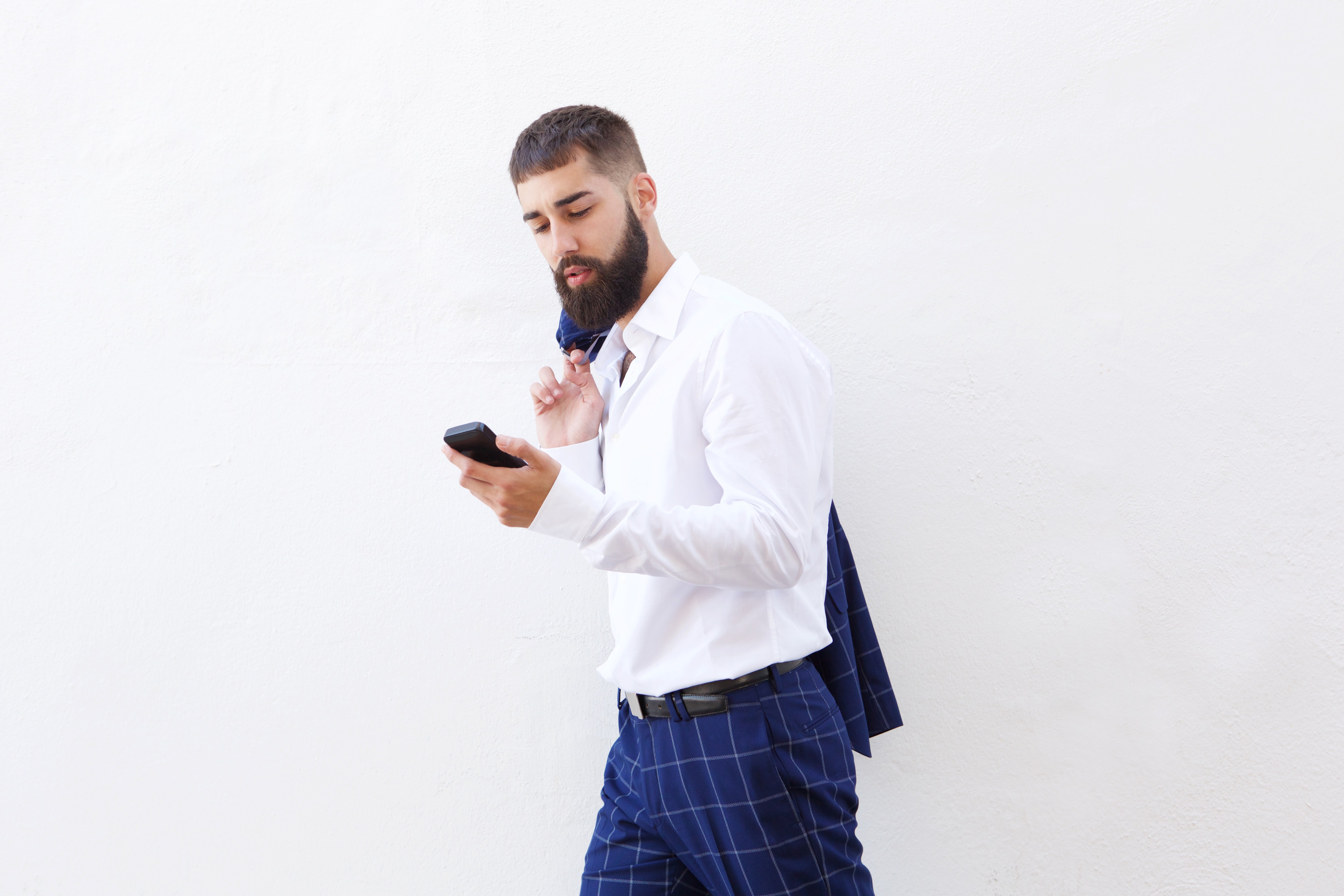 serious-businessman-walking-with-cellphone-and-UABJXKP