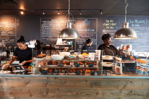 Staff working behind counter in busy coffee shop