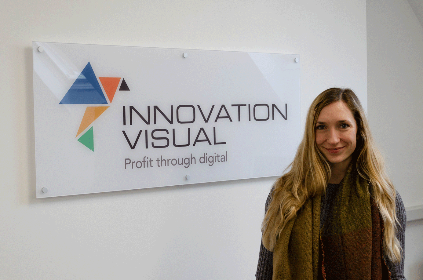 Miriam Gooch, Digital Marketing Executive for Innovation Visual in front of Innovation Visual Logo