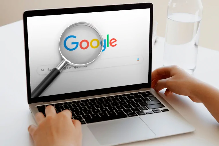 magnifying glass over Google search page on laptop screen