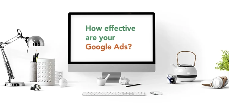 How effective are your Google Ads text written on desktop screen surrounded by desk objects 