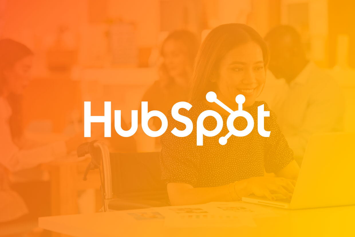 HubSpot monthly update graphic with logo overlayed over business women working on a laptop 