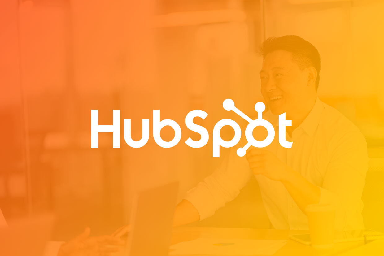 HubSpot monthly update graphic with logo overlayed over businessman working at laptop 
