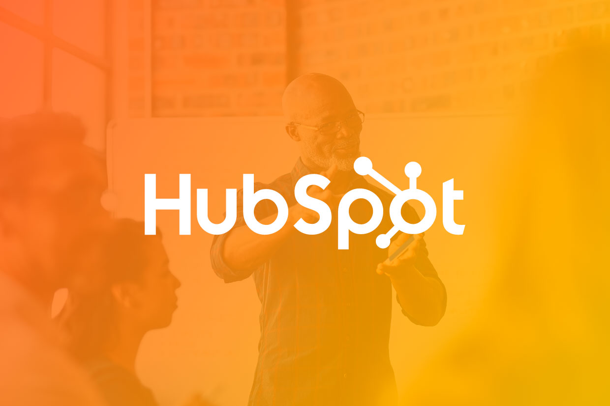 HubSpot monthly update graphic with logo overlayed over man giving presentation
