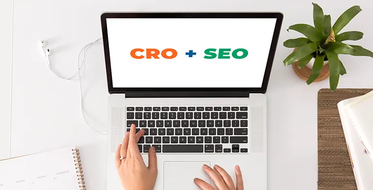 CRO plus SEO on laptop screen - top-view with hands